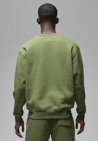 Olijfgroen sweatshirt met een relaxte pasvorm, verlaagde schouders, ribgebreide manchetten en een ronde hals. Zachte textuur, minimaal ontwerp en geen zichtbare logo's.