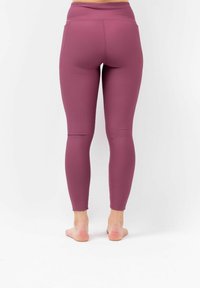 Hooggewaist ribgebreide legging in diep mauve, met een strakke pasvorm en zonder zichtbare hardware. Ontworpen voor comfort en bewegingsgemak.