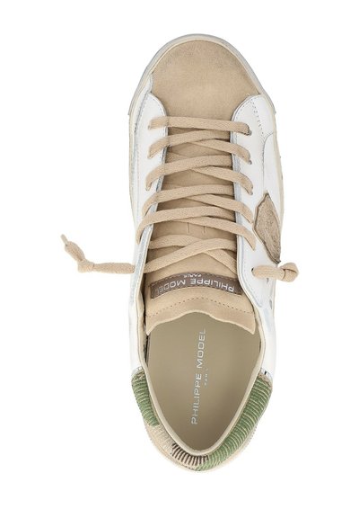 Baskets beiges et blanches avec des lacets marron, talon à motifs verts, logo Philippe Model Paris sur la semelle intérieure et la languette, lacets noués.