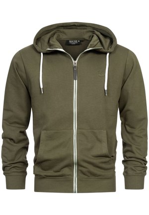 Olivengrøn lynlåstrøje med en tekstureret finish, hvid snor, forlommer og kontrasterende grøn lynlåsdetalje.