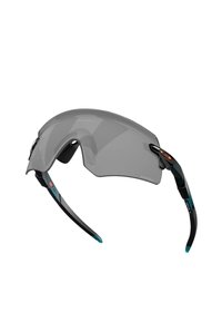 Occhiali da sole sportivi con lenti curve grigie, montatura nera e dettagli turchesi. Presentano un design leggero e impugnature testurizzate sulle aste.