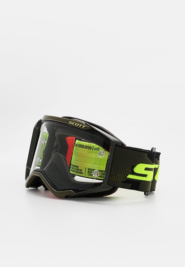 Gafas Scott con un marco negro, lente transparente y correa de camuflaje verde con logo. Diseñadas para deportes con bordes reforzados y ventilación.