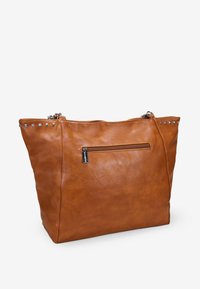 Bolso tote de cuero marrón con cierre de cremallera, bolsillo frontal y acentos de tachuelas metálicas en el borde superior. Textura suave y diseño espacioso.