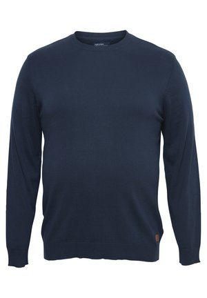 Navy blue crew neck sweater with long sleeves. Made of a smooth knit fabric, featuring ribbed cuffs and hem, with a small logo patch at the bottom.