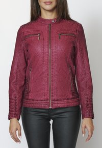 Burgundi faux nahkjope, millel on lukuga sulgemine, kõrge krae ja ribakujundus õlgadel ja küljel; esiküljel on lukugaTaskud.