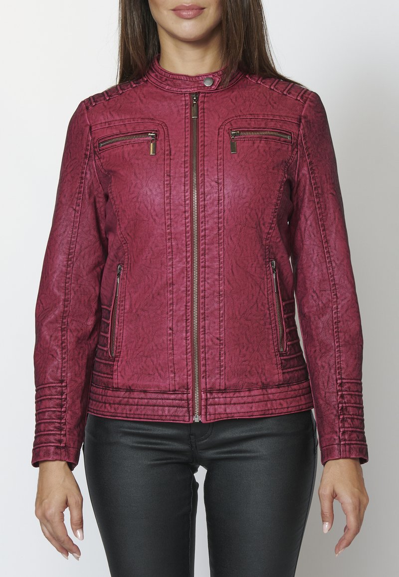 Burgundi faux nahkjope, millel on lukuga sulgemine, kõrge krae ja ribakujundus õlgadel ja küljel; esiküljel on lukugaTaskud.