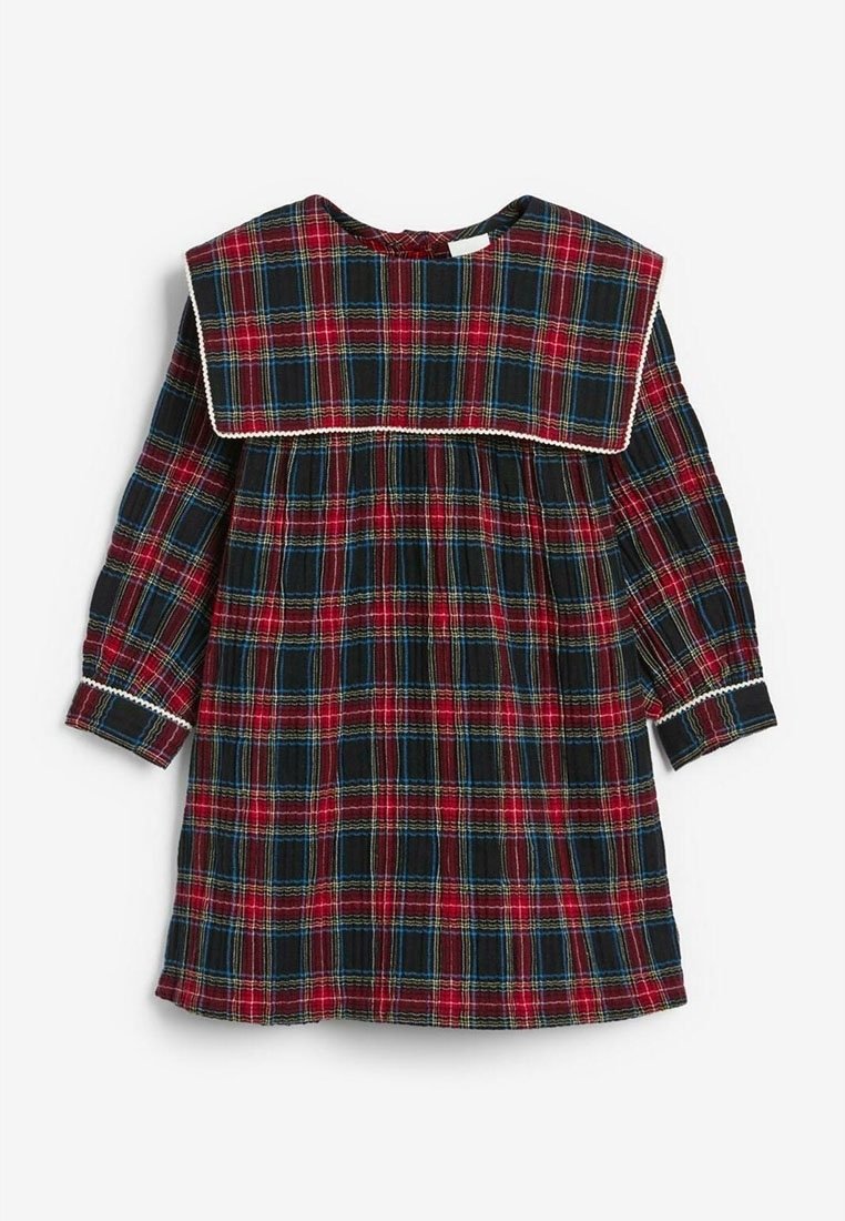 Robe à carreaux rouges et noirs avec des accents bleus, un grand col carré, des manches longues et un détail de taille froncée. Présente des bordures blanches.