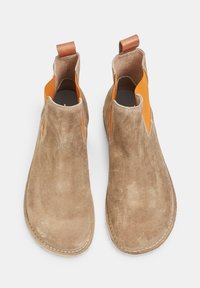 Bottines Chelsea en suede tan avec des accents en tissu orange, des panneaux élastiques sur les côtés et une languette en cuir marron. Détails cousus autour de la semelle.