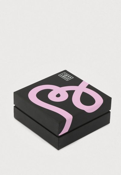 Štvorec s čiernym vonkajším obalom, ružovým abstraktným dizajnom a malým logom v hornom rohu; matný povrch s hladkou textúrou.