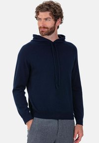 Sweat à capuche bleu marine avec cordon de serrage à l'avant, poignets et ourlet côtelés ; confectionné en tissu tricoté doux pour un confort optimal.