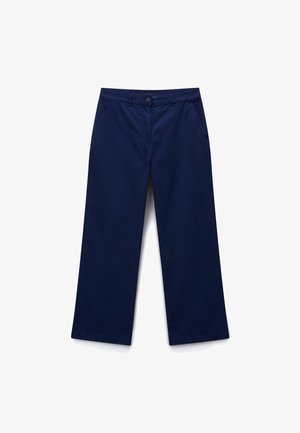 Pantaloni blu navy a gamba larga con chiusura a bottone e zip, tasche frontali inclinate e passanti per cintura, posati distesi su sfondo bianco.