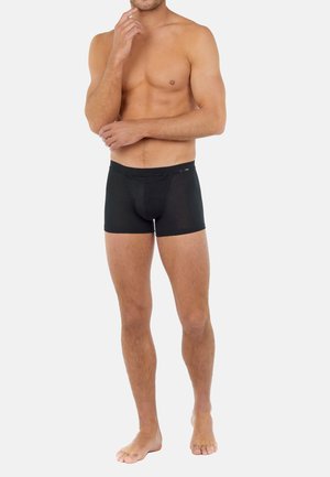 Zwarte boxershorts gemaakt van zachte, rekbare stof. Kenmerken zijn een snug fit, middellange benen en een gladde tailleband zonder zichtbare branding.