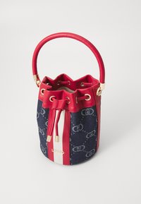 Czerwona skórzana torba typu bucket z denimu, złotymi akcentami, zapięciem na sznurek i detalem logo. Posiada okrągłą rączkę oraz kontrastowe paski.