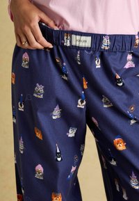 Námořnické pyžamové kalhoty s hravým vzorem různých kreslených zvířat v party kloboucích. Elastický pas se štítkem Joules. Měkká textura látky.