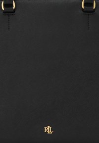 Črna teksturirana torba z zlatimi dodatki in logotipom na dnu. Ima nastavljive naramnice in minimalističen dizajn.