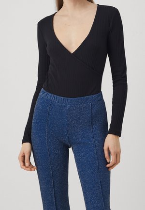 Černý žebrovaný bodysuit s dlouhým rukávem a hlubokým V výstřihem, doplněný modrými třpytivými kalhotami s elastickým pasem, které mají hladkou texturu a dobře padnoucí střih.