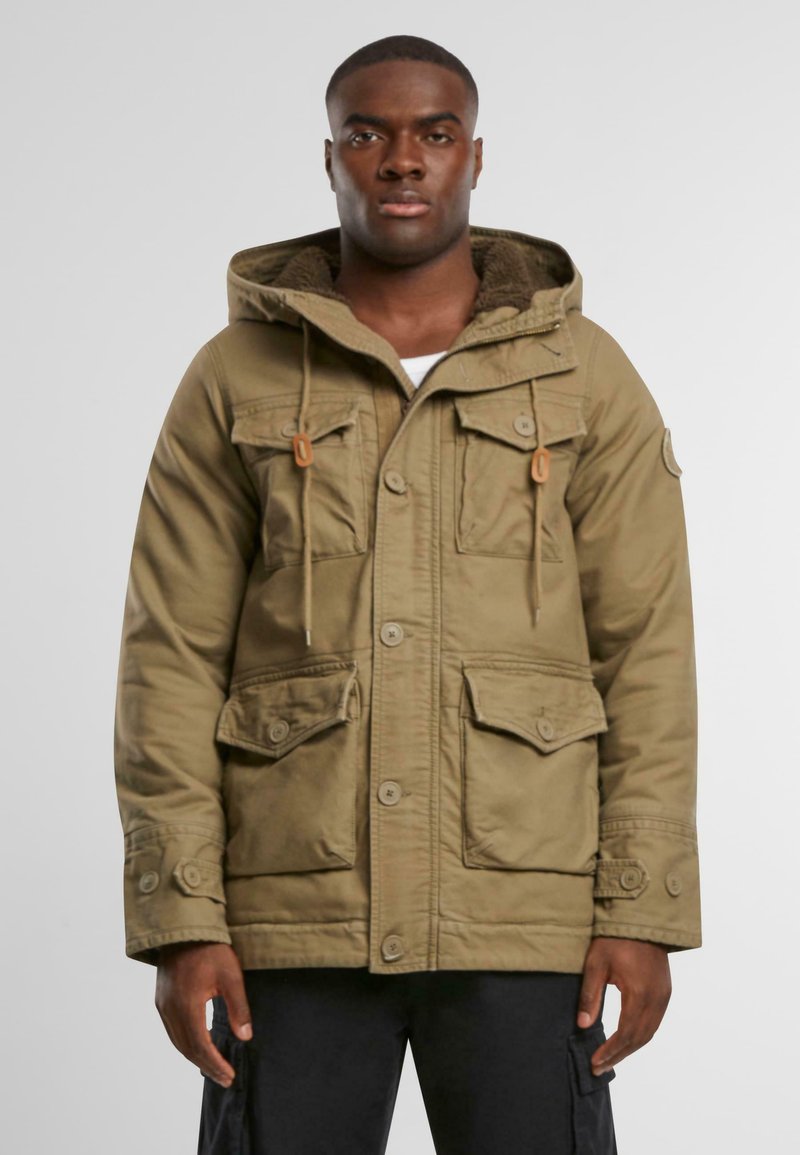Olivengrøn parka med hætte, der har et for af pels, fire frontlommer, knaplukning og snoredetaljer.