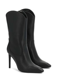 Botines de cuero negro con punteras afiladas y tacones de aguja. Textura elegante y suave con sutiles recortes laterales y cierre de cremallera en la parte posterior.