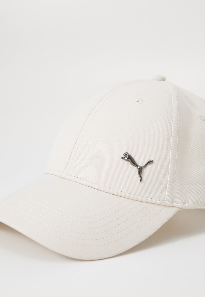Casquette de baseball blanche en tissu texturé, ornée d'un logo métallique Puma à l'avant. Visière courbée avec des détails de couture visibles.