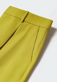 Heldere gele, op maat gemaakte broek van gestructureerde stof, voorzien van een vlakke voorkant, ceintuurlussen en subtiele plooien met nette stiknaden.