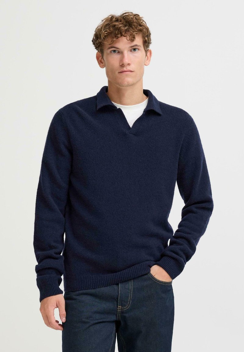 Marineblauwe gebreide pullover met V-hals en kraag, met lange mouwen en geribde boorden en zoom. Zachte textuur, casual ontwerp.