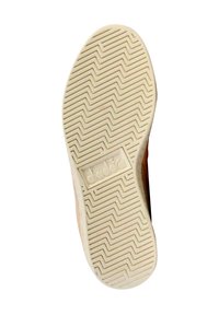 Semelle de chaussure avec un design en caoutchouc crème texturé ; présente un motif de crampons en zigzag et un détail de logo en relief dans une forme rectangulaire.