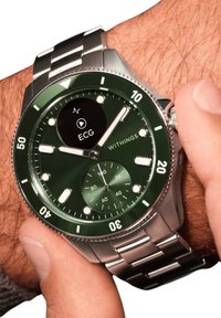 Grünes Edelstahl-Smartwatch mit ECG-Funktion, silberner Lünette, runder Zifferblatt, drei Nebenziffern und Metallarmband mit polierten Gliedern.