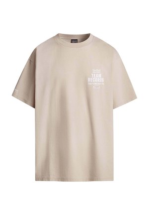 Camiseta de algodón beige con cuello redondo y mangas cortas. Presenta texto blanco en el frente, detalla "Registros del Equipo Red Bull Racing" y otras inscripciones.