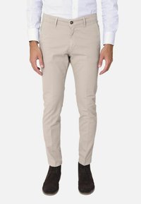 Chinos beige con una vestibilità slim, dotati di chiusura a bottoni, cinque tasche e un tessuto in cotone liscio. Adatti per un abbigliamento casual.