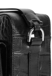 Svart läderväska med en texturerad, krokodilsliknande mönstring, rektangulär form, justerbar rem och spänne i silverfärgad metall.