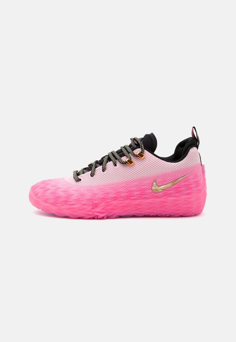 Ροζ και λευκό αθλητικό Nike χαμηλού τύπου με ανάγλυφη ροζ σόλα, χρυσό σήμα Nike, μαύρη γλώσσα και μαυρόασπρα κορδόνια σε λευκό φόντο.
