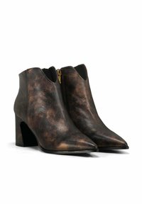 Bottines en cuir-texturé marron avec un bout pointu, un talon bloc haut et un détail de fermeture éclair décoratif sur le côté. Matériau lisse semblable à du cuir.