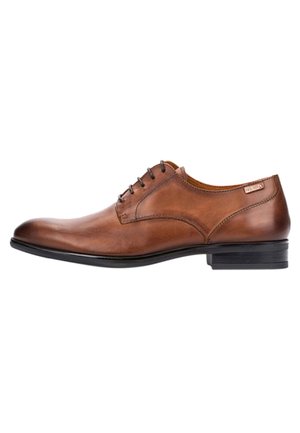Chaussure habillée en cuir marron avec une finition lisse, bout arrondi, cinq lacets et un petit talon noir. Détails de couture subtils sur le dessus.