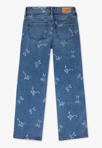 Spijkerbroeken met een lichte blauwe wassing, voorzien van een herhaald wit strikpatroon, rechte pijpen en traditionele achterzakken.