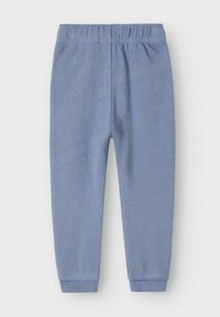 Blaue Baumwoll-Jogginghosen mit elastischem Bund, schmal zulaufenden Beinen und gerippten Säumen. Der Stoff hat eine weiche, strukturierte Oberfl äche.