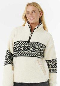 Witte fleece pullover met een half-rits hals, met een zwart geometrisch patroon over de borst en textuurstof. Zijzakdetails.