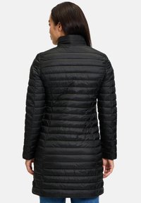 Sort dunjakke med lodrette syninger, høj krave og lange ærmer. Glat tekstur, mellemlangt design og tætsiddende silhuet.
