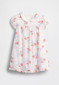 Vestido branco com padrões de flores vermelhas e azuis, com gola redonda, mangas curtas com folhos e um bolso no lado esquerdo.
