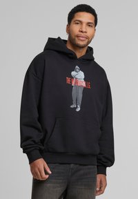 Zwarte hoodie met een voorzak, voorzien van een afbeelding van een persoon en de tekst "THE NOTORIOUS B.I.G." in het rood. Zachte stof, comfortabele pasvorm, ribgebreide boorden.