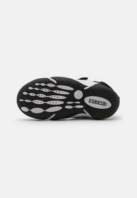 Suola in gomma nera con accenti bianchi, dotata di un motivo testurizzato per la presa e un design ergonomico. Include il marchio "Geox" sul lato.