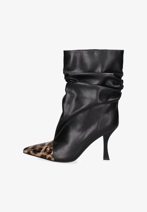 Bottine en cuir noir avec un design froncé, bout pointu et un accent imprimé léopard sur le capuchon du pied. Elle comporte un talon fin.