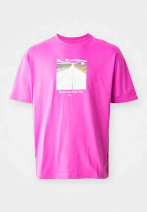 Lyserød bomulds-t-shirt med et firkantet grafisk design, der viser en snoet vej og teksten "Der er ingen målstreg" under et virvel-design. Korte ærmer.
