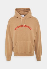 Brown hoodie with a relaxed fit, featuring a front pocket, ribbed cuffs, and an embroidered "VINTAGE SUPPLY" logo in red.