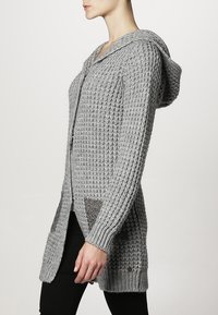 Cardigan grigio lavorato a maglia con cappuccio, caratterizzato da un motivo testurizzato, tasche laterali e un dettaglio con bottoni all'orlo. Maniche lunghe e apertura frontale.