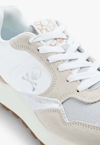 Sneaker in materiale scamosciato e mesh, con una combinazione di colori grigio e bianco. Accentuato con un logo a teschio e suola in gomma testurizzata.