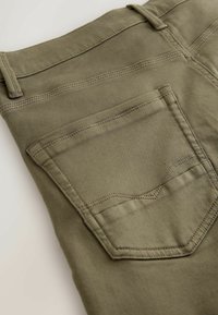 Olivově zelené džíny z denimu s zadní kapsou s prohnutým švem, čistým provedením a minimalistickým designem. Měkká textura a pevný materiál.