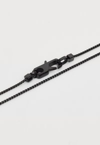 Must must ketchain must kastiga kastmenet tumedatel hallil pinnal.