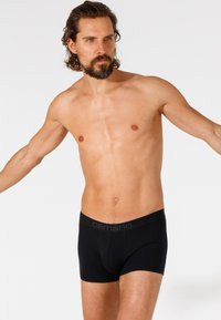 Czarne bawełniane bokserki z miękkim pasem, na którym widnieje nazwa marki "camano" w odcieniu szarości. Projekt ma dopasowany krój o średnim podwyższeniu.