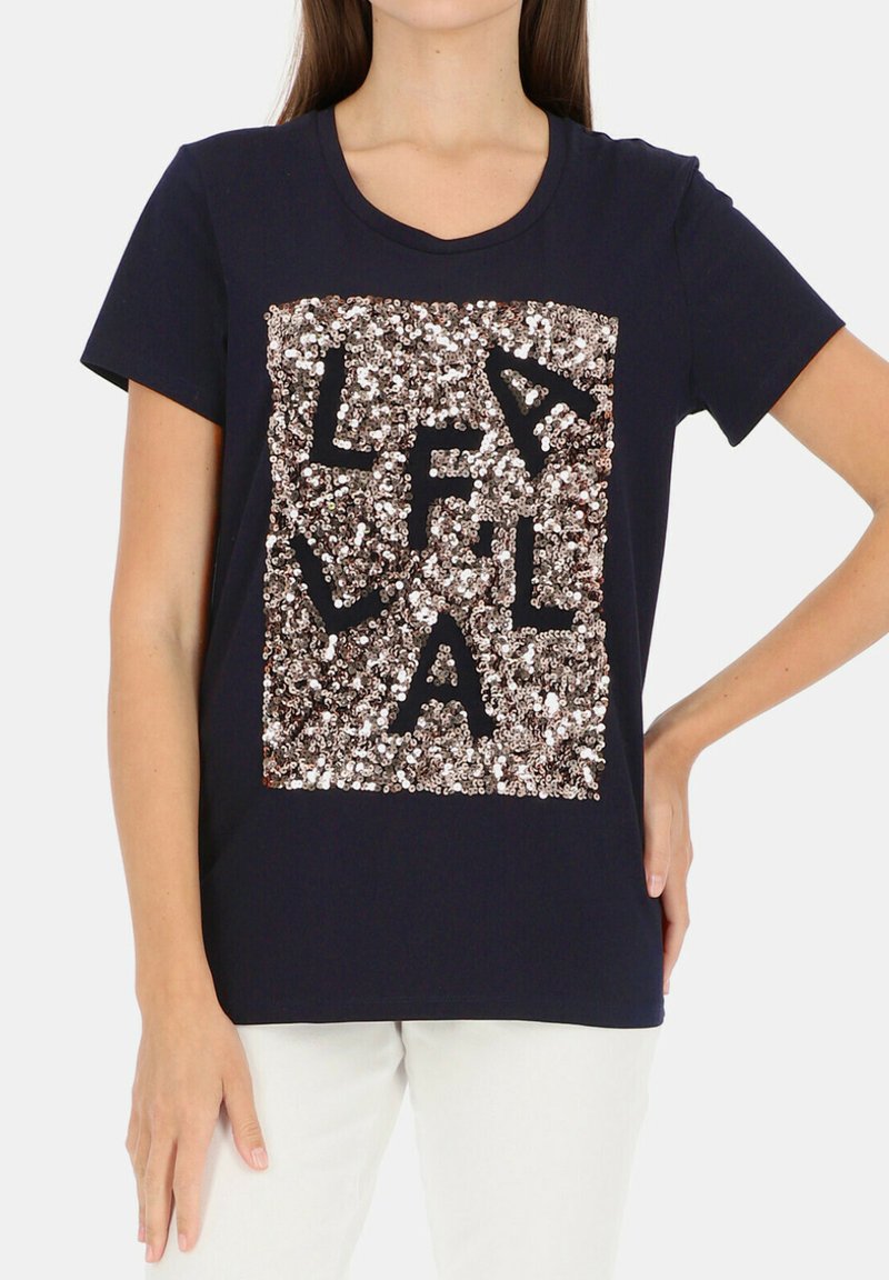 Granatowa bawełniana koszulka z krótkim rękawem, z prostokątnym wzorem z cekinów w kolorze różowego złota, z czarnymi literami ułożonymi wewnątrz cekinów.