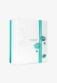 Biała pudełko prezentowe z turkusowymi akcentami i wytłoczonym wzorem kwiatowym; posiada turkusową wstążkę obejmującą pudełko oraz nadrukowany cytat.